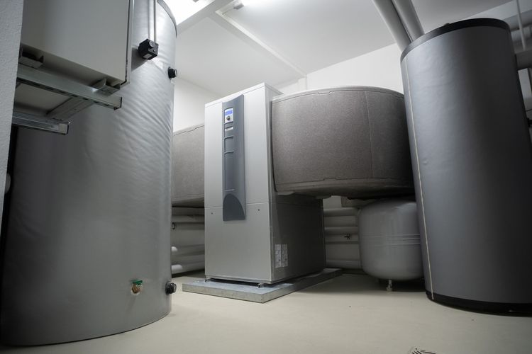 Insulated hot water cylinders and a heat pump in a plant room